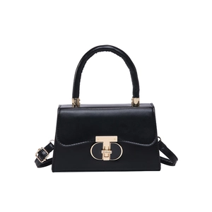 Classic black leather handbag with round top handle and gold T-bar buckle in white background