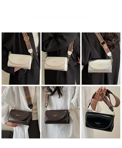 Detail of the wide jacquard shoulder strap and the textured leather crossbody bag