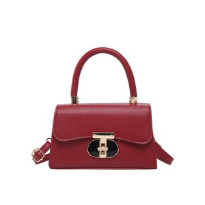 Elegant red faux leather crossbody bag featuring a unique gold T-shaped lock closure