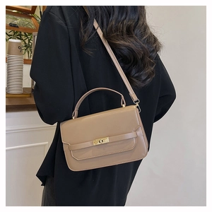 Detail of khaki leather handbag with gold twist lock and adjustable crossbody strap