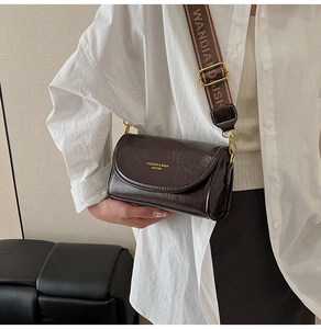 Detail of vintage brown leather crossbody bag featuring wide jacquard logo shoulder strap