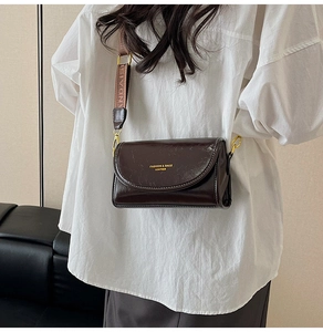 Detail of dark brown vintage faux leather crossbody bag with adjustable wide woven strap