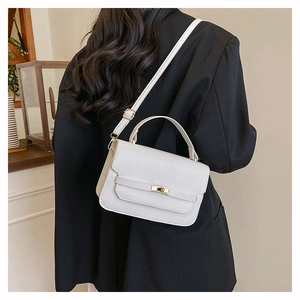 Detail of white rectangular crossbody bag with golden twist lock and adjustable strap