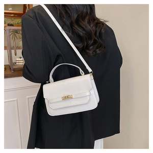 White leather handbag with gold metal clasp shown on model for size and style