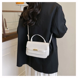 White leather shoulder bag with gold clasp shown from back view on model's body
