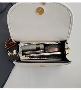 Vertical view of the spacious inner compartment of the beige crossbody bag with pockets
