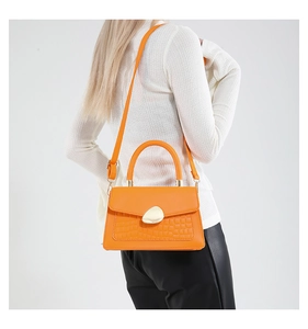 Détail du sac bandoulière orange en cuir PU avec motif crocodile et fermoir doré chic