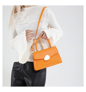 Détail du sac à bandoulière orange vif en cuir PU avec motif crocodile et boucle blanche