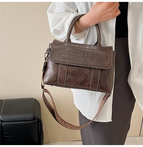 Dettaglio della borsa tote in pelle morbida con patta a coccodrillo e tracolla larga