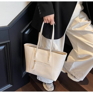 Minimalist white tote bag detail featuring zipper pocket and tassels on steps
