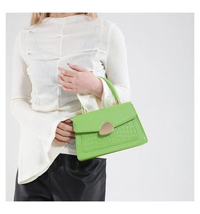 Détail du sac à main vert vif gaufré crocodile avec boucle dorée en forme de goutte d'eau
