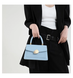 Détail du sac à main bleu clair en cuir de crocodile avec fermoir métallique doré