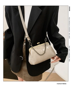 Detail of beige crocodile embossed shell bag with vintage frame clasp and chain strap