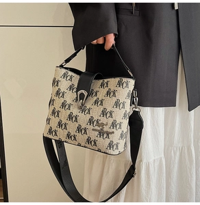 Detail of the woven texture handbag with ARCK print and sleek black leather strap