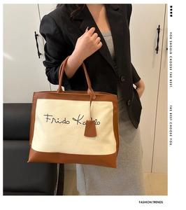 Detailed shot of canvas tote bag with brown leather trim and Frida Kahlo logo