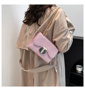 Vue détaillée du sac à bandoulière rose pailleté avec chaîne dorée et fermoir en T