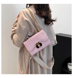 Détail du sac rose scintillant avec fermoir en T doré et bandoulière en chaîne chic