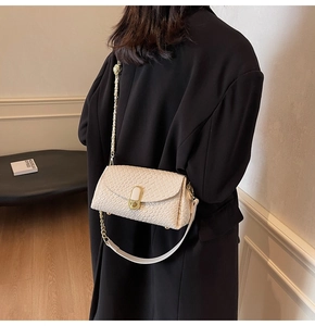 Détail du sac oreiller en cuir tressé crème avec chaîne dorée et fermoir sur modèle
