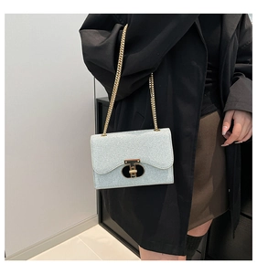 Détail du sac à chaîne argenté avec fermoir doré élégant et texture pailletée
