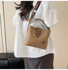 Detail of printed bucket bag showing a kangaroo metal logo and a wide lettered shoulder strap