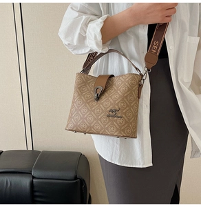 Detailed side view of brown bucket bag with monogram print and gold kangaroo logo