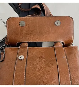 Dettaglio borsa in pelle coccodrillo con fibbia magnetica argento e cuciture bianche a vista
