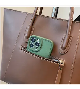 Close-up of brown leather tote bag showing external zipper pocket with phone storage