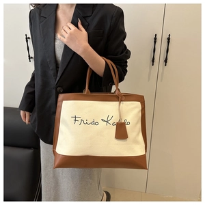 Chic beige canvas tote bag with brown leather trim and stylish calligraphy script