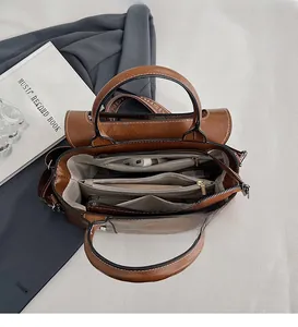 Dettagli interni di una borsa shopping marrone con trama a coccodrillo e scomparti
