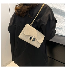 Détail du sac carré à paillettes dorées avec fermoir en T et bandoulière chaîne