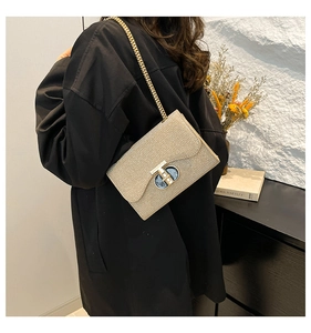 Gros plan d'un sac à main à paillettes champagne doré avec chaîne et fermoir en T