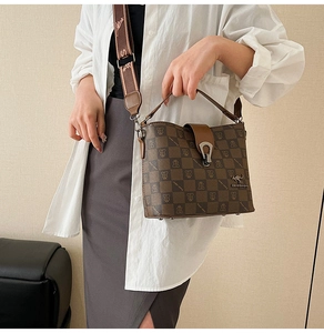 Close-up of a brown monogram bucket bag with leather handles and metallic kangaroo logo
