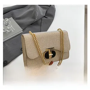 Détail du sac à paillettes champagne doré avec fermoir en T et chaîne à billes dorée