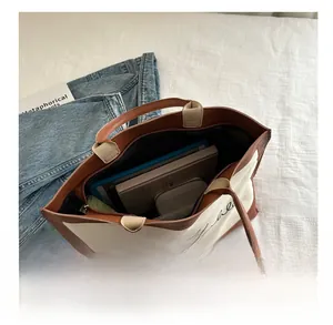 Internal storage detail of large canvas tote bag with books and tablet showing capacity