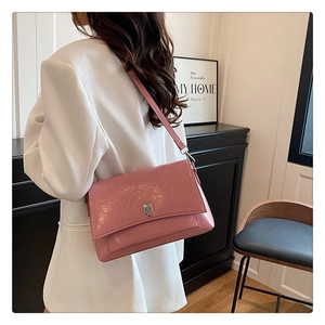 Detail der rosa Schultertasche aus Wachsleder mit silberner Schnalle und glänzendem Finish