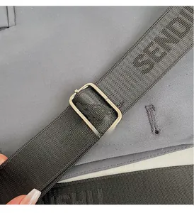 Detail of premium metal adjustment buckle and woven strap with letter pattern on bag