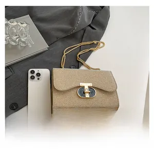 Vue détaillée du sac à chaîne doré avec boucle en T et référence de taille sur magazine