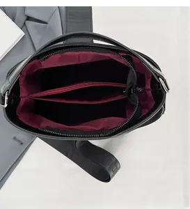 Interior detail of large capacity handbag with wine red lining and zip compartment