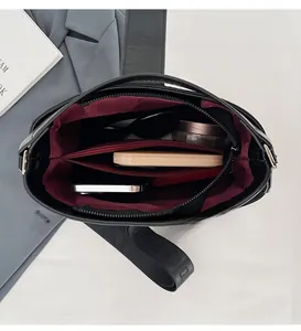 Detailed interior of black tote bag showing spacious compartments and red fabric lining