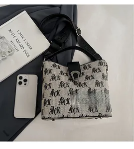 Detail view of large capacity printed bucket bag with wide shoulder strap and metal buckle
