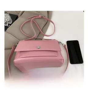 Details der rosa Schultertasche aus Leder mit Kapazitätsvergleich zu einem Mobiltelefon