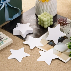 Dettaglio di stelle in carta bianca da 10cm su superficie testurizzata per decorazioni
