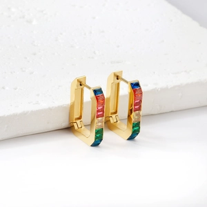 Macro shot of rectangular gold hoop earrings featuring rainbow gradient gemstone inlay