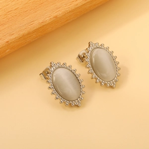 Detailed close-up of vintage oval silver earrings with gray cat eye stone inlay