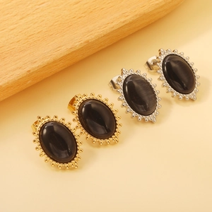 Detail of vintage oval stud earrings with black cat-eye stone in gold and silver finish
