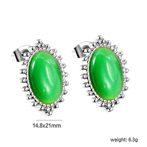 Close-up of vintage oval silver earrings with green cat eye stone and beaded edge details