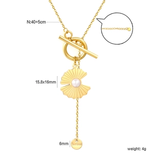 Detail of gold necklace showing the OT buckle, pearl fan pendant, and S.steel logo tag