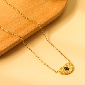 Detail der 18K vergoldeten Halskette mit Hammerschlag-Struktur und schwarzem Wassertropfen