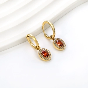 Macro shot of gold-plated hoop earrings with an oval red stone and micro-pave setting