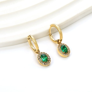 Detailed close-up of 18K gold hoop earrings with emerald green stones and diamond accents